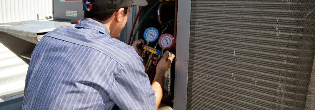 HVAC technician servicing a condenser unit in East Renton Highlands